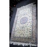 An Isfahan ivory ground part silk rug with scrolling vines and palmettes around a central medallion,