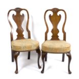 A pair of George II walnut side chairs, with carved shell motifs above shaped splats,