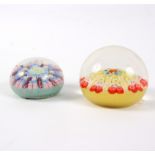 Two glass paperweights, both with floral and twisted cane decoration,