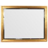 A rectangular wall mirror in a gilded frame,