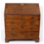 An 18th Century oak bureau, the sloping front revealing a fitted interior, above four long drawers,
