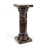 A red and white veined marble column, with hollowed column and square base,