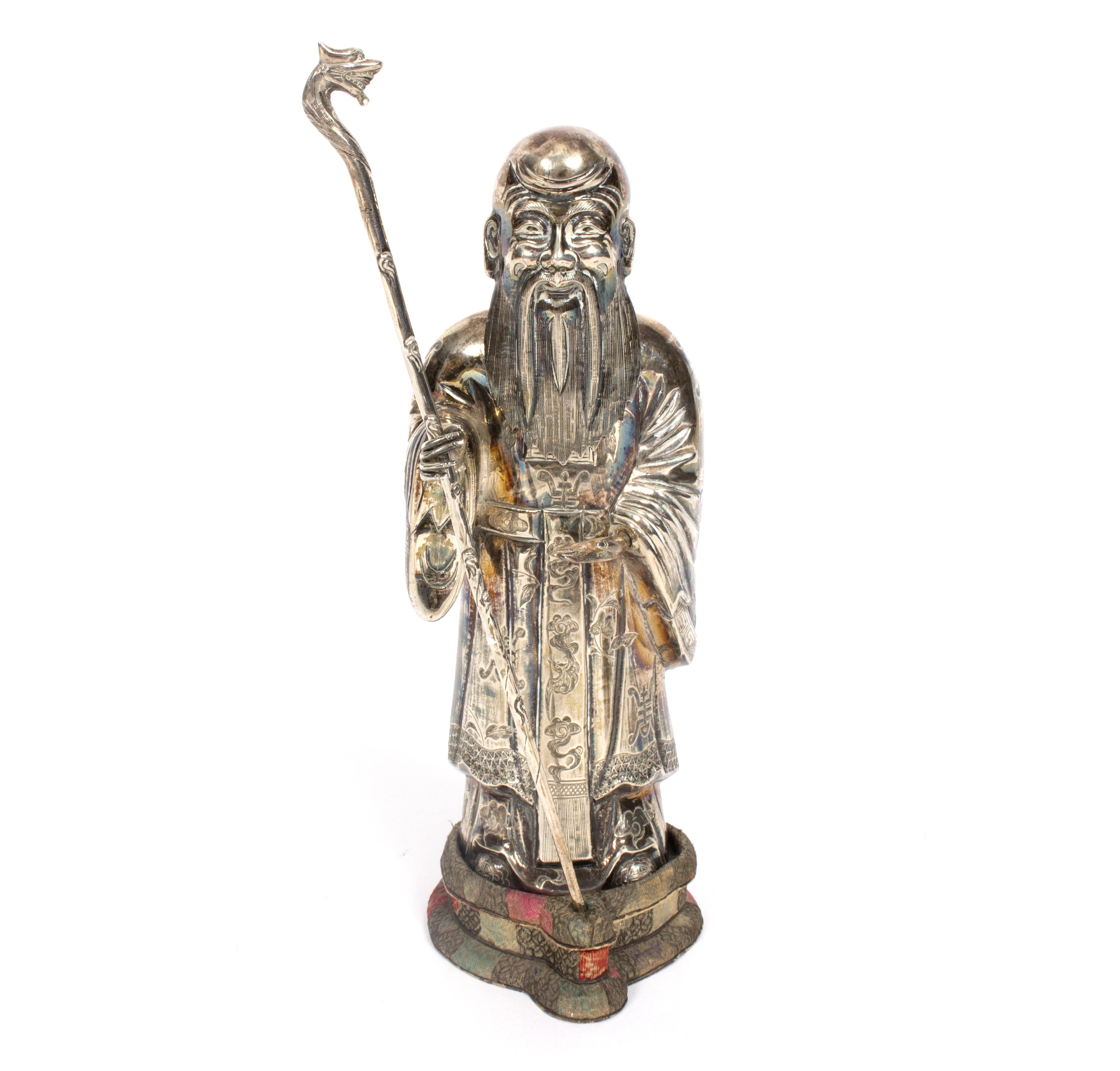 A silver coloured metal figure of a bearded immortal wearing a Mandarin coat and holding a staff,