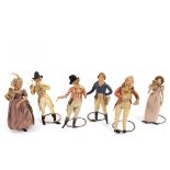 A group of six Regency dolls, with overstuffed kid leather bodies and silk dress, on wire stands,