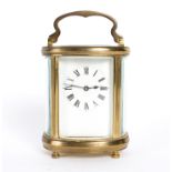 An oval gilt brass cased carriage clock, the rectangular white enamel dial with Roman numerals,