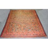 An Eastern rug worked in blues and reds to a pink ground,