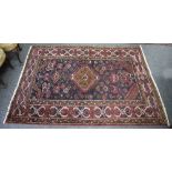 An West Persian rug with central medallion to a dark blue ground within a geometric border,