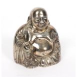 A white metal figure of Buddha, seated his hand resting on his knee,