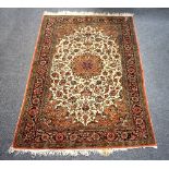 An Isfahan rug with central medallion on a camel coloured floral ground within a floral border,