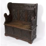 A late 19th Century carved oak hall seat in the form of a settle with box seat and shaped ends, 101.