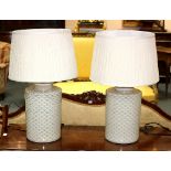 A pair of modern ceramic table lamps, each with geometric decoration to a cream ground,