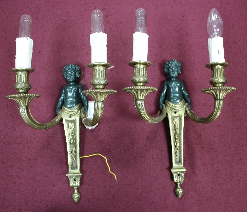 A set of eight two-branch wall lights, each with branches issuing from a patinated putto,