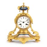 A 19th Century French mantel clock with porcelain mounted urn finial,