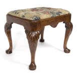 A George I walnut stool, with carved acanthus to the knees on cabriole legs with pad feet,