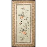 A Japanese silk embroidered panel depicting a bird and flowering branch,