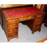 A mahogany veneered pedestal desk with surround of nine drawers,