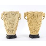 A pair of resin vases to simulate ivory, with elephant mask handles, incised figures in landscapes,