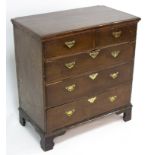 A Georgian oak chest, of two short over three long drawers on later bracket feet,