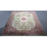 An Indian carpet, the central medallion to a pale green field with pink corner spandrels and border,