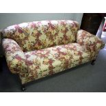 An upholstered sofa, on ball and claw feet,