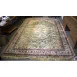 A modern silk rug decorated oval scalloped motif to a pale green ground within a multi-field border,