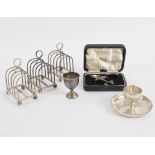 Three silver toast racks, London 1956, two silver egg cups and a cased spoon and pusher,