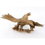 A root carving of an eagle, with outstretched wings,