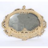 An oval wall mirror in a carved gilded and limed frame,