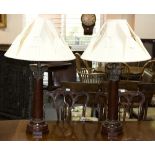 A pair of mahogany table lights with gilt metal Corithian capitals on octagonal bases,