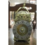 A reproduction lantern clock of usual form, the silvered dial with Roman numerals,