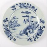 An 18th Century blue and white plate, decorated a lake, building, garden landscape, etc.