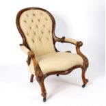 A Victorian walnut armchair with padded scroll arms,