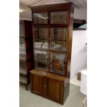 A mahogany three section bookcase, each enclosed by a pair of leaded doors with cupboard beneath,