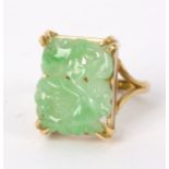 A Chinese carved jadeite ring the rectangular plaque claw set to a gold shank,