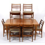 G Plan, an extending dining table, on tapering legs with eight ladder back chairs,