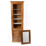 Manner of Heals, a limed oak glazed cabinet with a glazed door above a single panelled door,