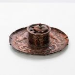 A Newlyn style Arts & Crafts copper ink stand, embossed fish swimming, fitted ceramic liner,