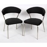 A pair of modern chairs on chrome supports