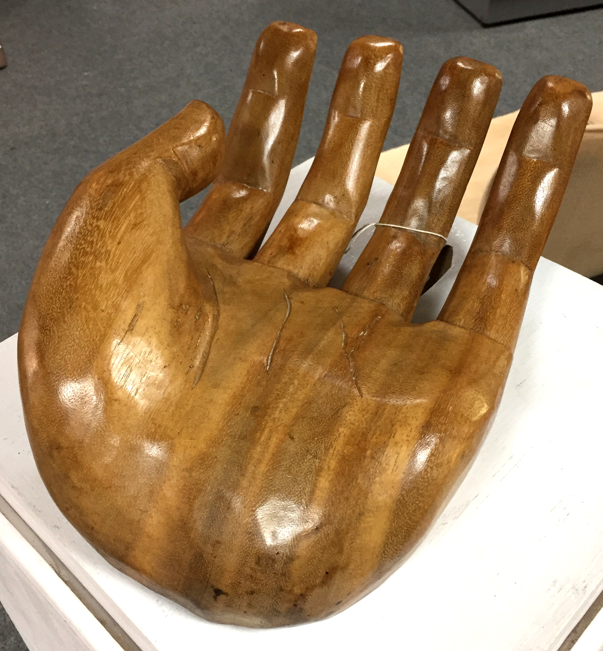 A carved wooden human open hand,