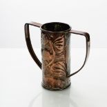 A Newlyn style Arts & Crafts copper two-handled tankard, embossed with fish and stylised foliage,