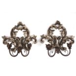 A pair of Italian silvered wall lights each with a sconce on the wall support,