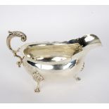 A silver sauce boat, TH, Birmingham 1900, with C scroll handle on three hoof feet, 21cm wide,