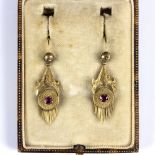 A pair of Victorian pendant earrings, each in yellow unmarked metal with a single stone to centre,