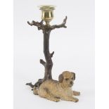 A cold painted bronze candlestick, the support a recumbent dog,