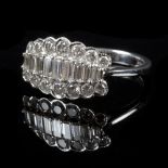 A diamond dress ring set with nine graduated baguette cut stones flanked by a row of graduated