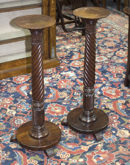 A pair of Regency mahogany torchères, each with spiral carved column, circular base, on three feet,