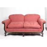 An upholstered two-seater sofa on ball and claw feet,