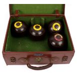 Four wooden bowls, with impressed dachshund mark, in a leather case,