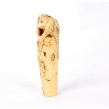 A Japanese carved ivory parasol handle, Meiji period, modelled as a kappa climbing a stump,