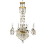 A Regency style glass chandelier with twin gilt metal coronet finials hung prismatic drops and